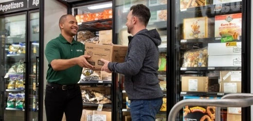 Employee handing a box to a customer