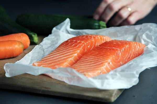 raw salmon on cutting board in kitchen.
