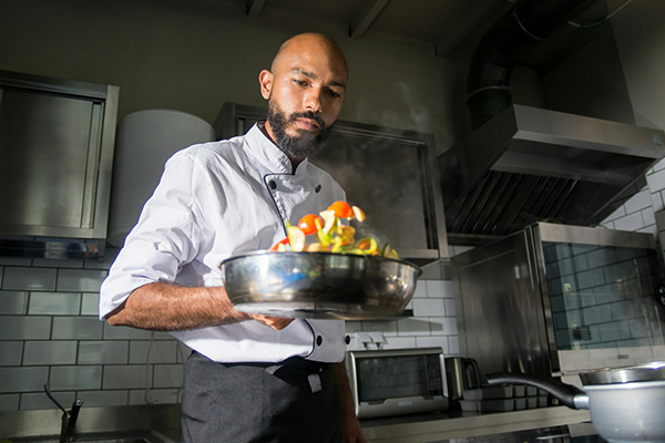chef cooking with a pan and vegetables