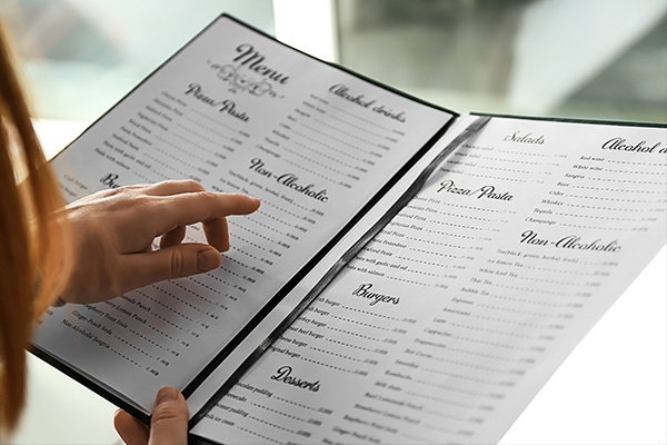 woman pointing to items on an open menu.