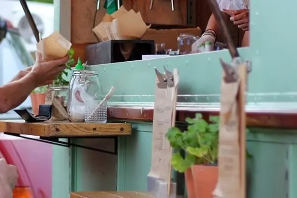 Person ordering at a food cart window.