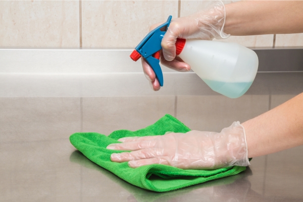 spraying cleaning solution on kitchen countertop.