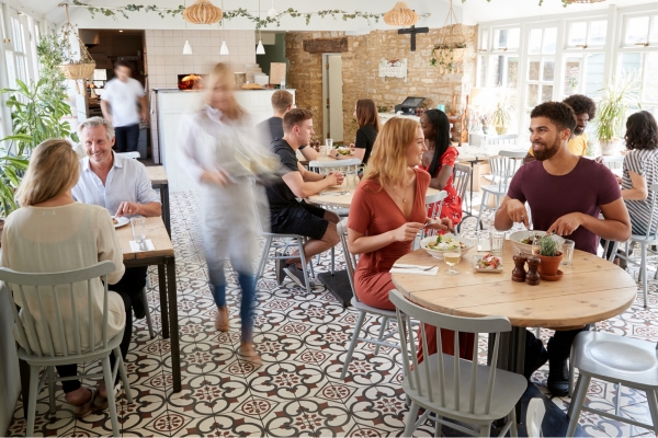 busy restaurant scene with tables and customers.