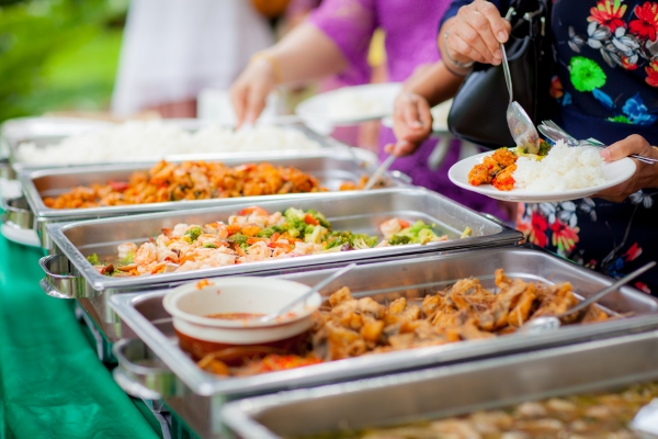 A buffet table filled with various dishes, including stir-fried vegetables, rice, and meat options.