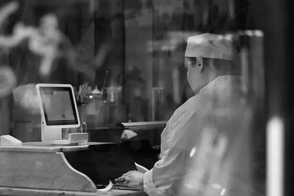 Restaurant worker working at a computer.