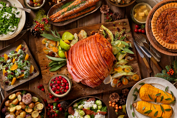 Sliced ham on table with other holiday food dishes