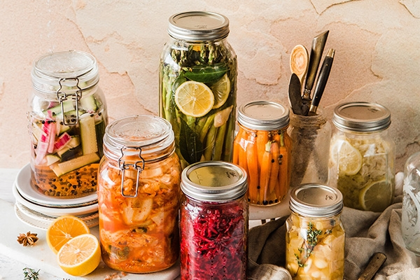 Jars of pickled vegetables sitting on a tabletop.