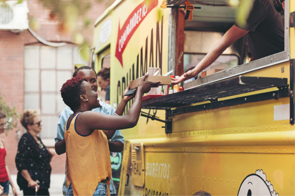 woman grabbing food from food truck window