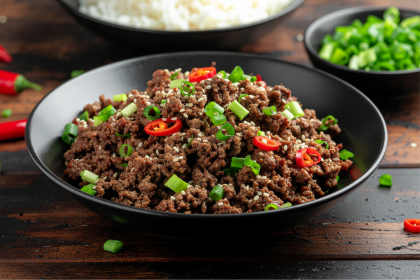 bowl of cooked ground beef with chopped vegetables on top