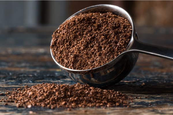 ground coffee beans in measuring cup