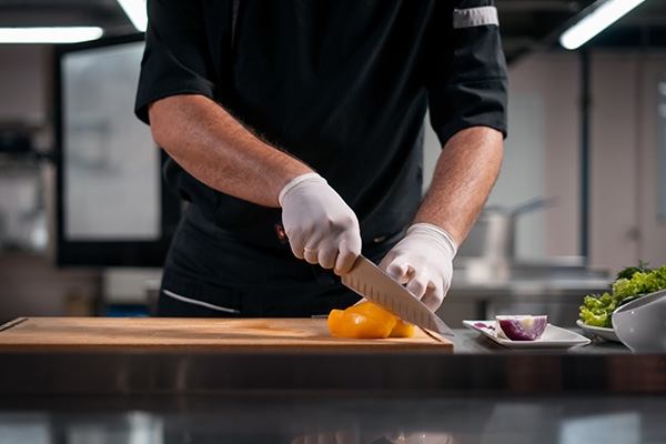 chef cutting a bell paper on a cutting board