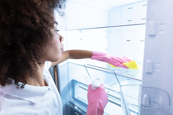 woman cleaning refrigerator in home.