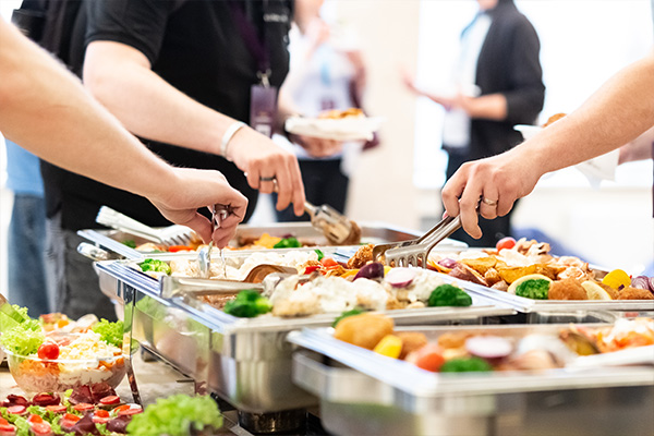 catering event with trays of food on linen table.