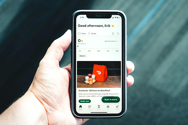 man holding phone with restaurant delivery app
