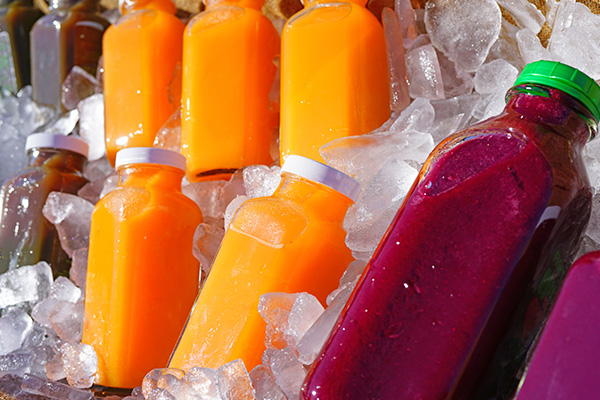 Bottles of fresh pressed juice encased in ice.