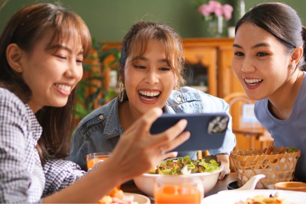three friends looking at social media page on phone