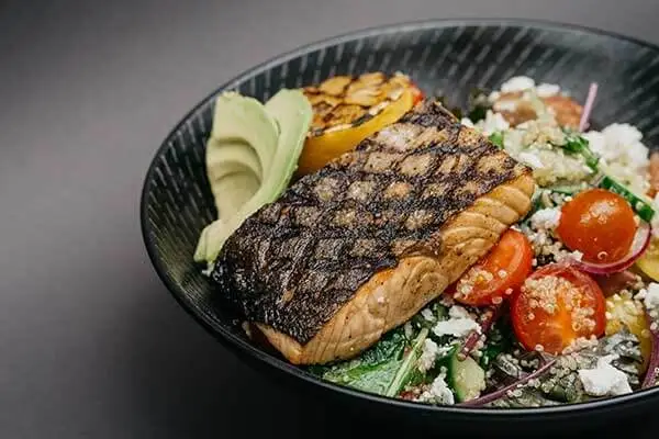 healthy bowl of salmon with quinoa and veggies