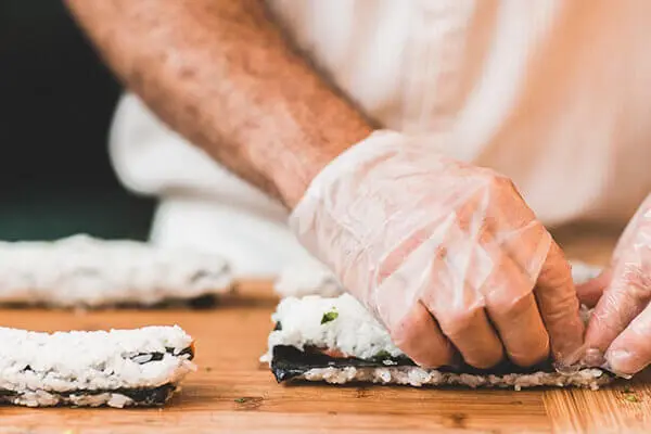 Hands rolling sushi