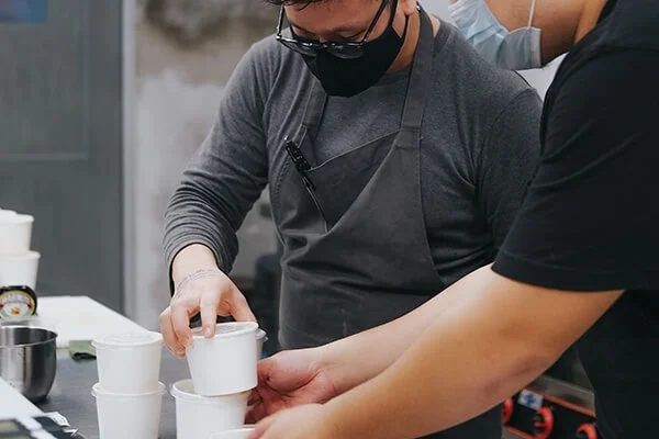 Restaurant workers putting food in to-go containers.