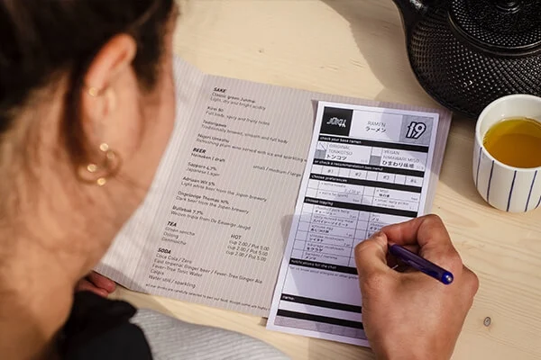 Person filling out a restaurant menu bill.