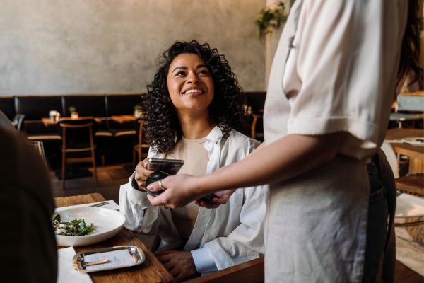 woman paying meal at restaurant.