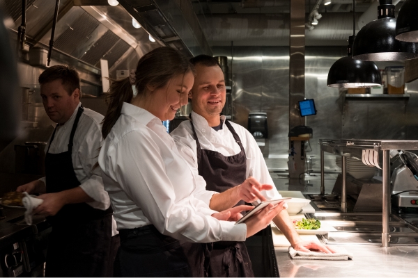 two restaurant staff talking to each other.