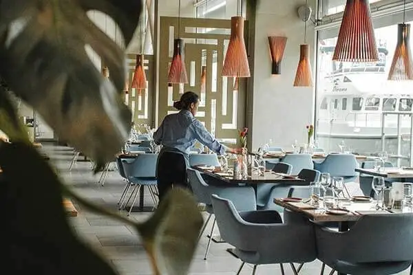 Waitstaff setting tables in a restaurant.