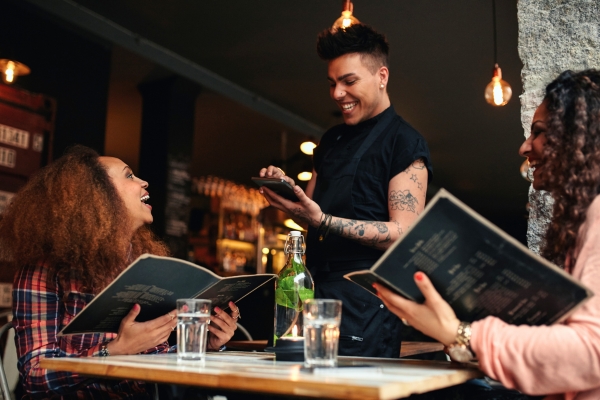 waiter talking to customers at restaurant.