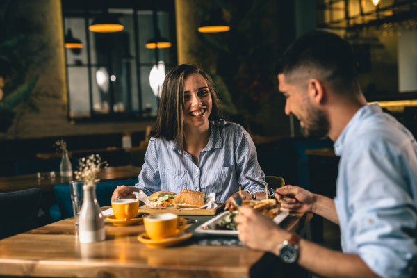 Couple enjoying dining out having sandwiches and coffee at a restaurant