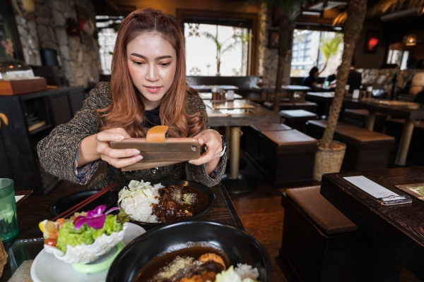 woman taking photo of food at restaurant